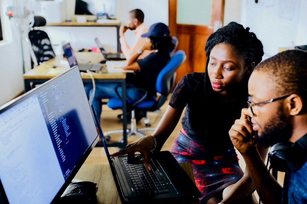 Tech sceen with lady manager teaching tranee the Pc or computer over the shoulder