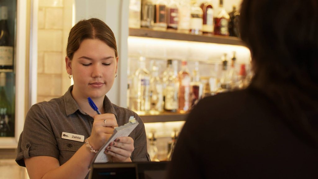 image of lady with note pad taking bar order