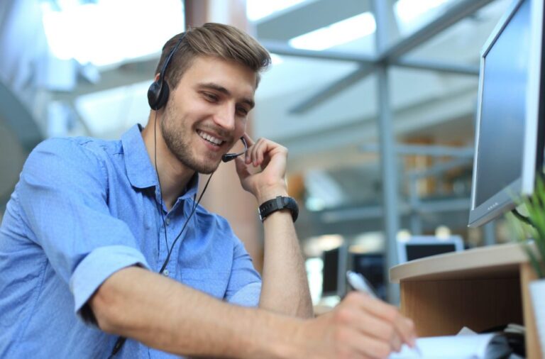 Man at desk on phone desk -self employment assistance service