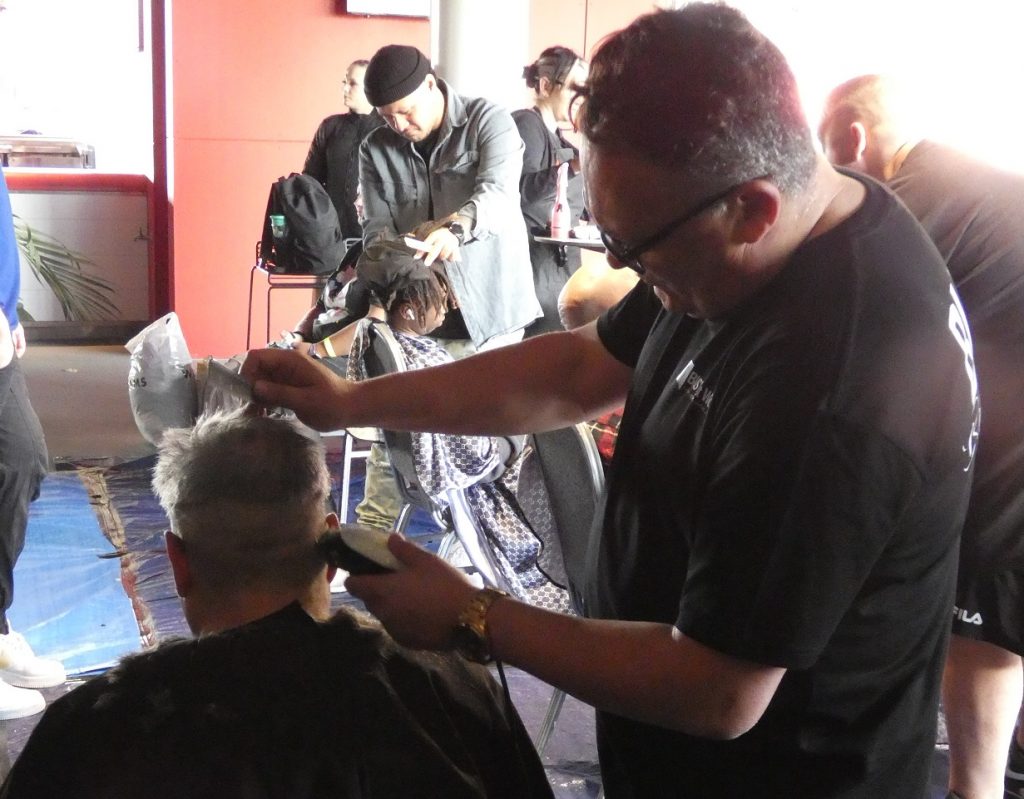 Man giving haircut at community homeless event