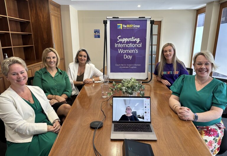 Group of female workplace leaders sitting around a board room table.