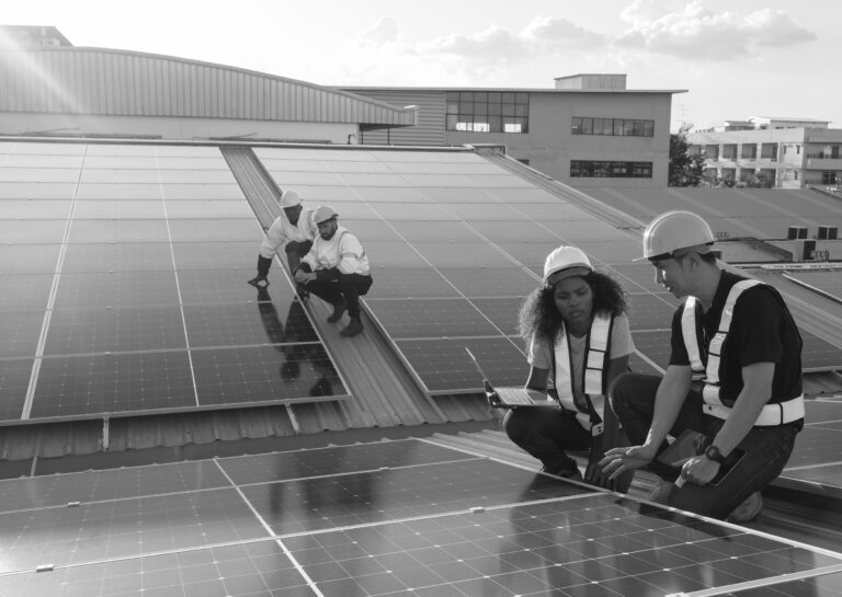 Apprentices on rooftop learning Solar panel installation for clean energy