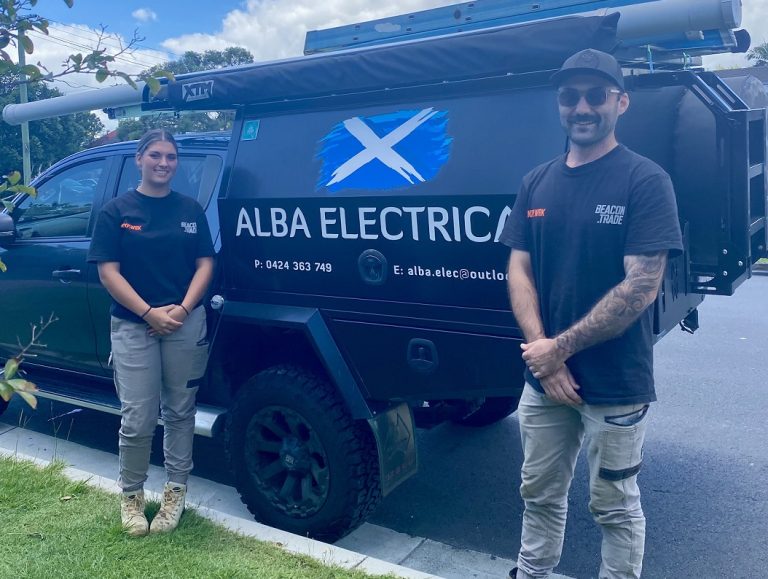 Female apprentice with her boss in front of work van