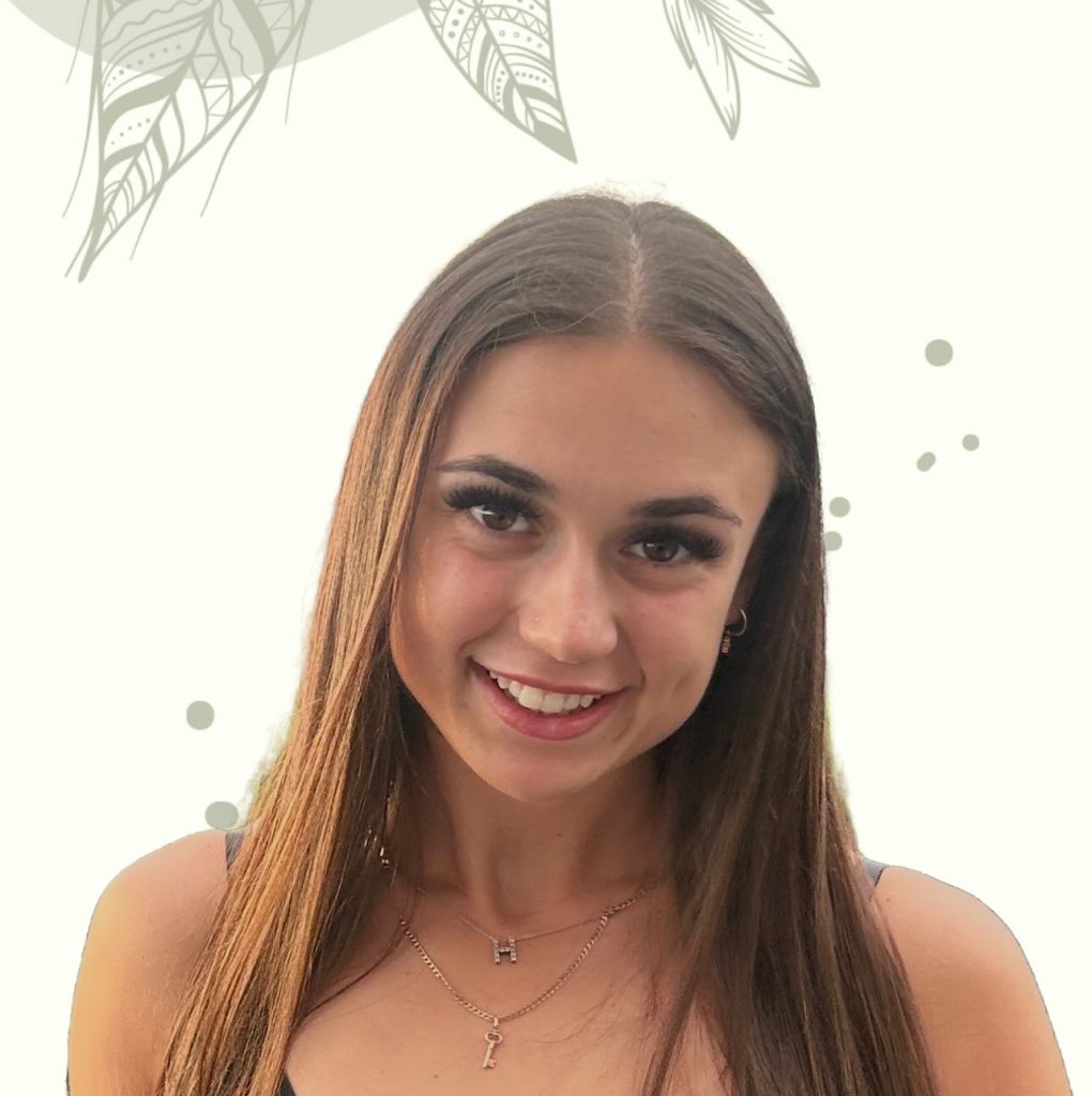 A young woman with long straight brown hair, wearing a key pendant necklace and black top, smiles at the camera, with support by BUSY at Work. Light background features subtle leaf and dot designs.